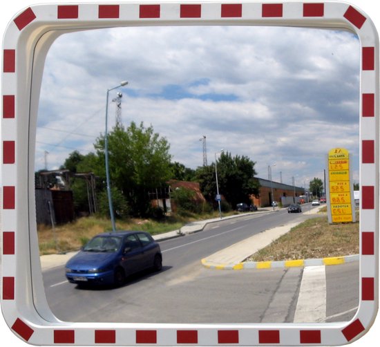 Een vierkante verkeersspiegel met rode en witte rand, die een straat met auto's weerspiegelt.