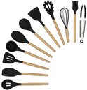 Ustensiles de cuisine noirs en silicone avec manches en bois : spatules, cuillère, louche, fouet, cuillère à pâtes, pinceau et pince.