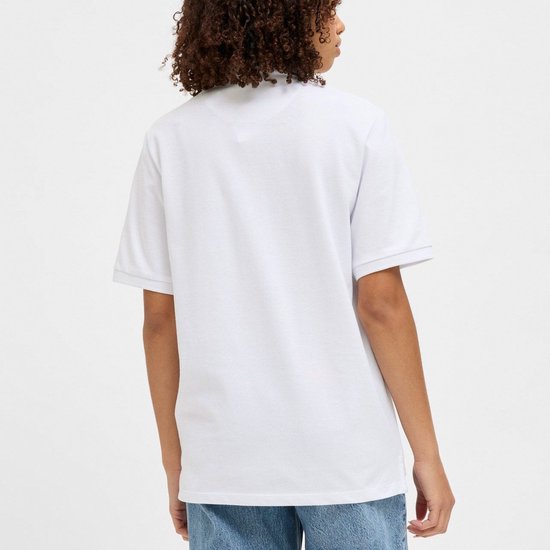 Vrouw met krullend haar draagt een wit poloshirt, voorkant.