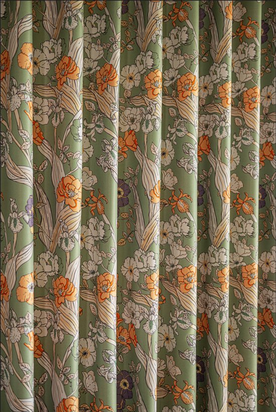 Close-up van een groen gordijn met een gedetailleerde bloemenprint in oranje, wit en paars.