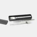 Service de couverts Brabantia avec cuillère, couteau et fourchette dans un étui de rangement gris foncé.