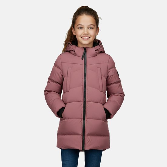 Jong meisje met een roze pufferjack met capuchon, zwarte boorden en jeans. Glimlacht met handen in de zakken.