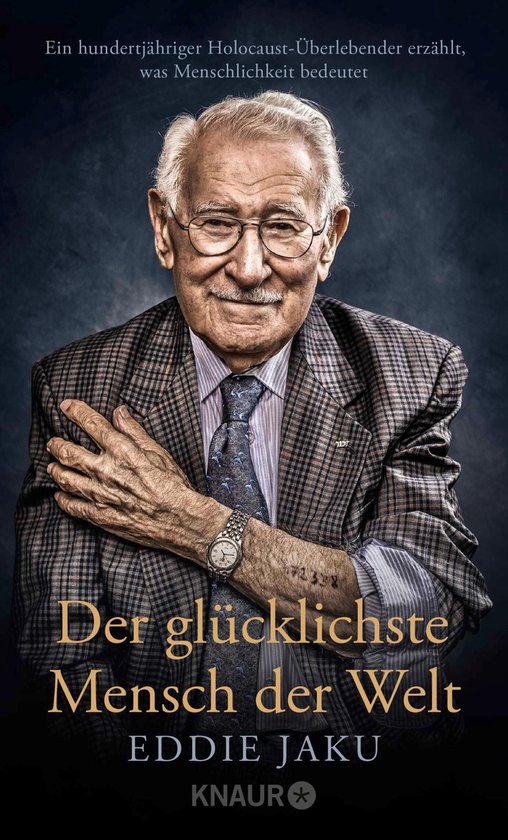 Omslag van het boek "Der glücklichste Mensch der Welt" met een zwart-witfoto van een lachende, oudere man met bril, gekleed in een geruit jasje.