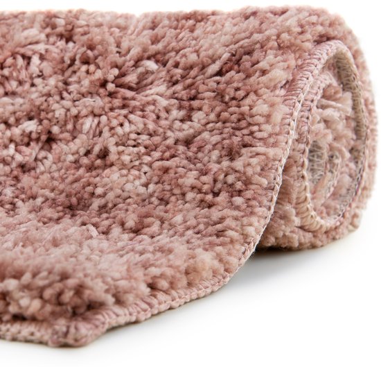 Gerolde roze badmat met een dikke, pluizige textuur.