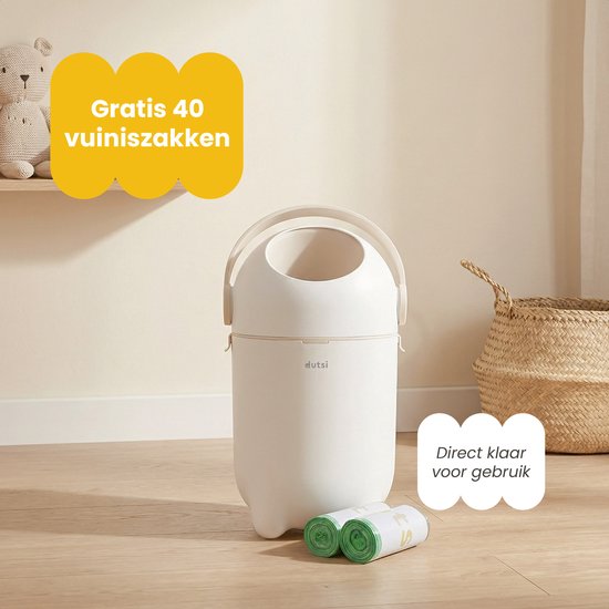 Witte luieremmer op pootjes, met een gesloten deksel, naast twee rollen groene vuilniszakken. "Gratis 40 vuilniszakken" "Direct klaar voor gebruik".
