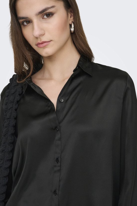 Close-up van zwarte satijnen blouse met knoopjes.