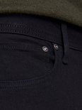 Detail van de voorzak van de zwarte jeans met twee klinknagels.