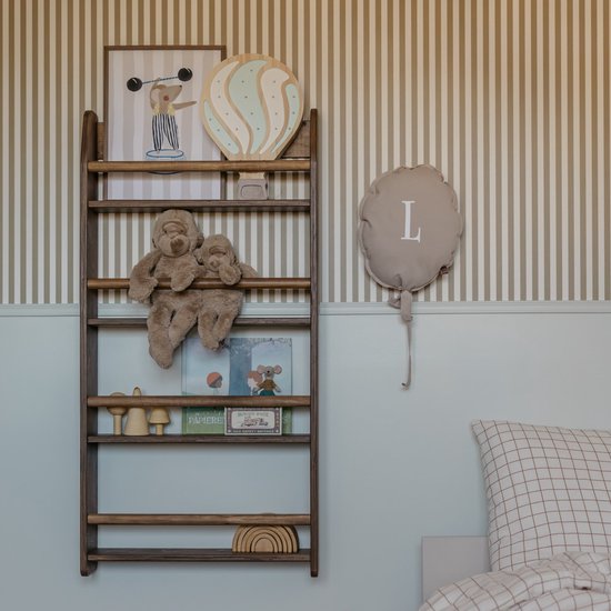 Bruin houten Montessori-boekenrek met vier planken tegen een gestreepte muur, gevuld met knuffels en boeken.