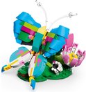 Papillon LEGO Creator 3 en 1 aux ailes bleues, vertes et roses, posé sur une fleur rose.