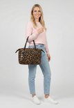 Vrouw met roze trui en jeans draagt een bruine shopper met luipaardprint.