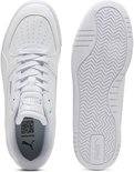 Twee witte Puma sneakers: een met vetersluiting, perforaties en logo's, de andere toont de zool met wafelpatroon en logo.