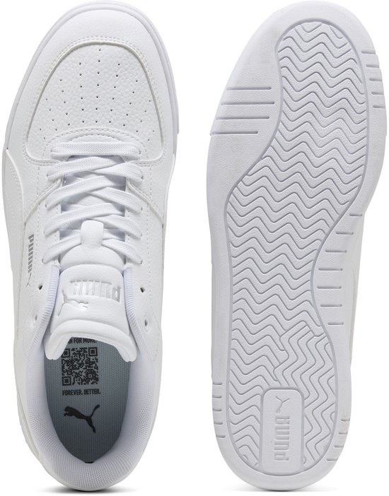 Twee witte Puma sneakers: een met vetersluiting, perforaties en logo's, de andere toont de zool met wafelpatroon en logo.