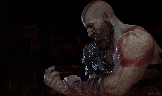 Close-up van Kratos, gericht op zijn gedetailleerde armen en rode tatoeages.