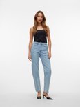 Model in lichtblauwe mom fit jeans met hoge taille, zwart topje en zwarte hakken.