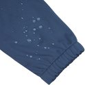 Close-up van een donkerblauwe jas mouw met waterdruppels en elastische zoom.