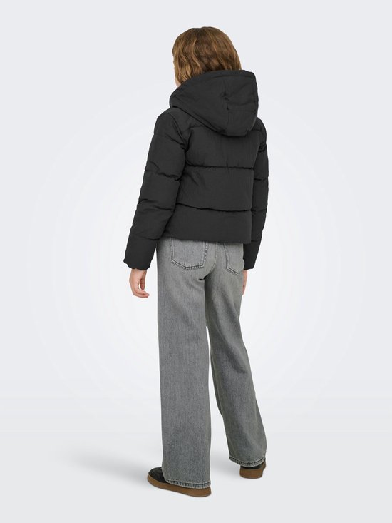 Meisje met lang blond haar, rug naar voren, draagt een zwarte pufferjas en grijze jeans.