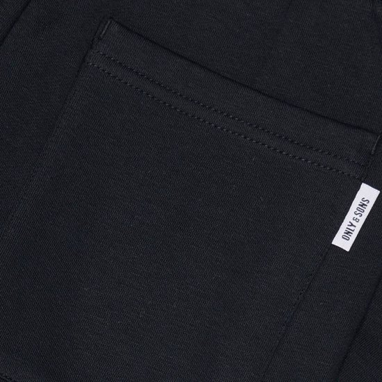 Detail van zwarte joggingbroek met opgestikte zak en logo.