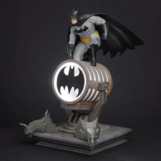 Batman-figuur bovenop een verlichte lamp met vleermuislogo, met vleermuisdecoraties aan de basis.