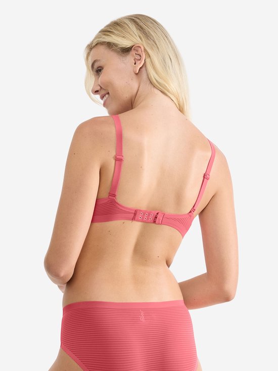 Model van achteren in koraalkleurige beha met horizontale ribbels en verstelbare bandjes.
