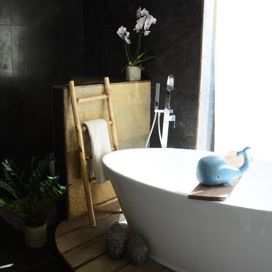 Houten decoratieve ladder met een witte handdoek, in een moderne badkamer met een wit bad.