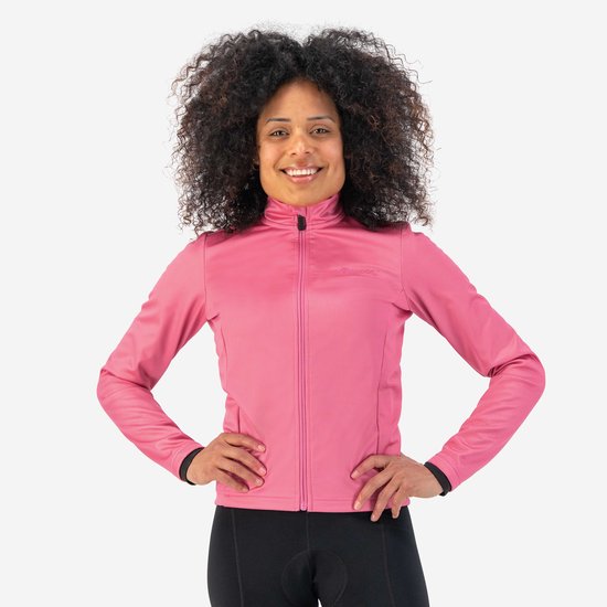 Model draagt een roze fietsjack met lange mouwen en zwarte manchetten. Ze draagt een zwarte fietsbroek.
