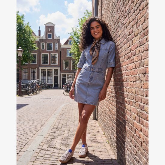 Model draagt een blauwe spijkerjurk met korte mouwen, ceintuur en luipaardprint sjaal.