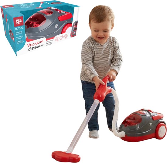 Een babyjongen speelt met een rode en grijze speelgoedstofzuiger. De verpakking staat ernaast.