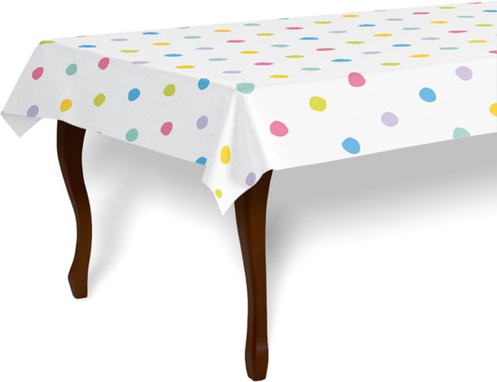 Een wit tafelkleed met veelkleurige stippen in pastelkleuren, op een tafel.