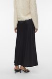 Femme portant une jupe noire et un manteau pelucheux crème, vue arrière.