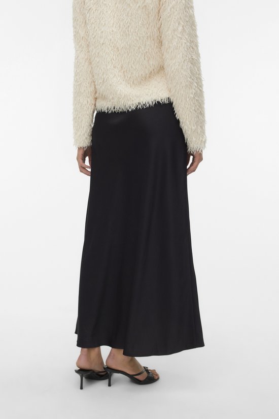 Femme portant une jupe noire et un manteau pelucheux crème, vue arrière.