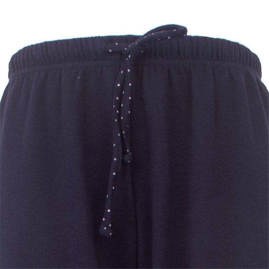 Detail van de tailleband van een donkerblauwe pyjamabroek met trekkoord met witte stippen.