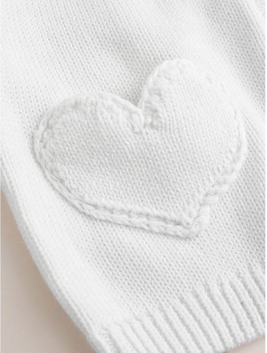 Geborduurd gebreid hart op de zak van een witte babyvest.