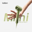 Een hand die de groene Laifen Mini föhn vasthoudt met de tekst 'Mini but Mighty'.