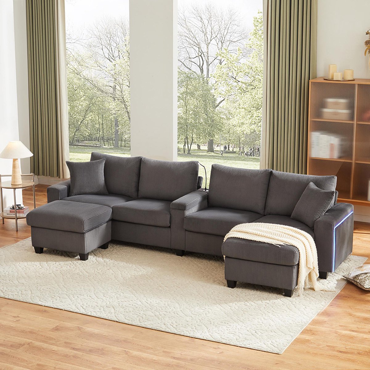 BLACKCOLORS U-vormige bank in corduroy met 2 krukken, leeslamp, neerklapbaar tafelblad, bekerhouder en USB/Type-C-poort, armleuningen aan beide zijden met decoratieve ledverlichting, grijs, afmetingen: 334 x 128,5 x 81 cm.