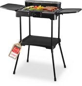 Zwarte elektrische barbecue met grill, worstjes en groenten. Met uitklapbare zijtafels, opbergrek en 'Outstanding' award label.