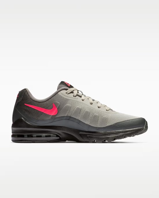 Grijze Nike Air Max Invigor sneaker met roze swoosh en zwarte zool.