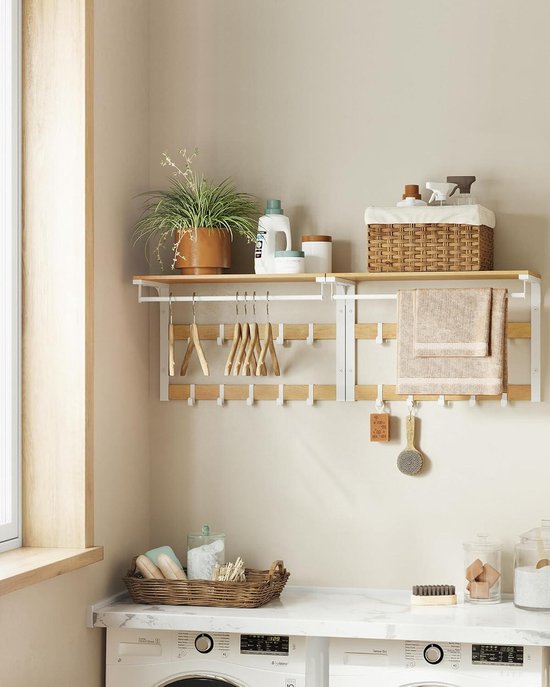 Witte metalen wandkapstok met eikenkleurige plank, kledingroede, en 10 haken. Hangende kleding, handdoeken en plant.