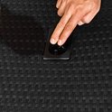 Hand die een handgreep op een zwarte polyrattan stoel indrukt.