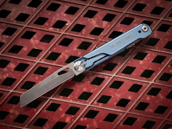 Blauw Black Eagle multitool mes met lichtblauwe handgreep, opengeklapt op rood rasteroppervlak.