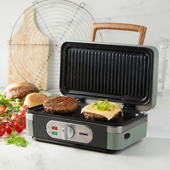 Groene grill met open deksel, twee hamburgerpatties en een met kaas gegarneerde patty.