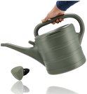 Hand houdt een donkergroene gieter vast, met de sproeikop ernaast. De gieter heeft ribbels.