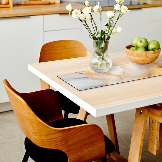 Chemin de table avec imprimé marbre gris, blanc et doré, sur une table claire avec des fleurs et des pommes.