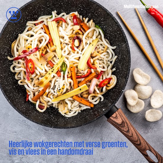 Wokpan gevuld met een wokgerecht van noedels, groenten, vis en vlees. Houten eetstokjes ernaast.