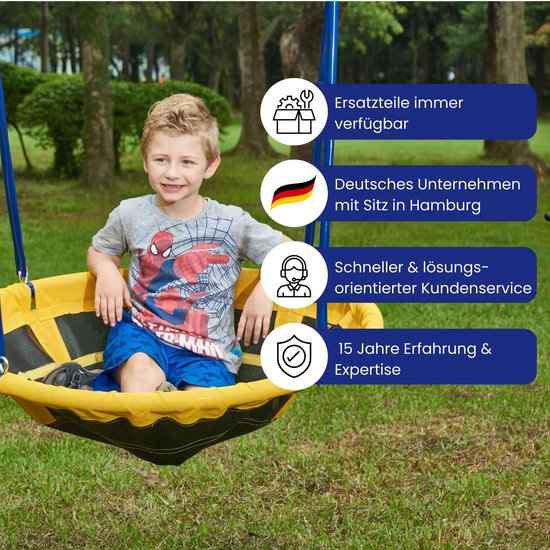 Jongetje in Spider-Man shirt in een grote ronde gele en zwarte schommel.