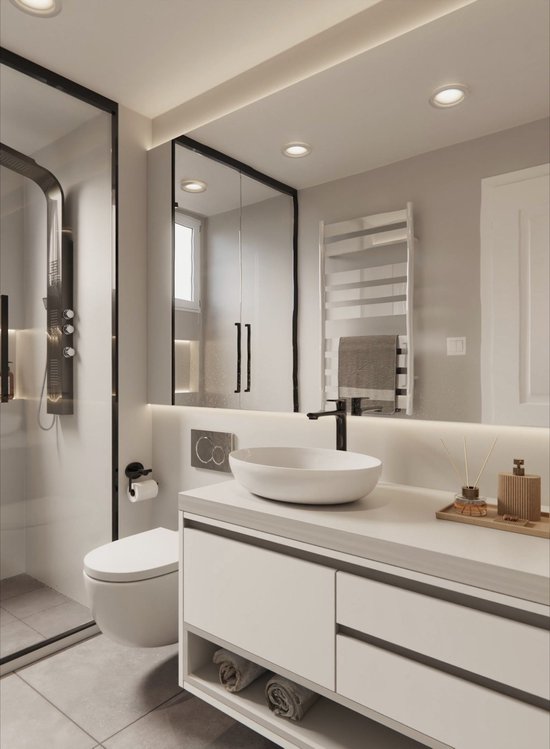 Moderne witte badkamer met toilet, wastafelmeubel, douche en een verwarmd handdoekenrek.