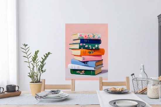 Een stapel kleurrijke boeken met bloemenprints op een roze achtergrond.
