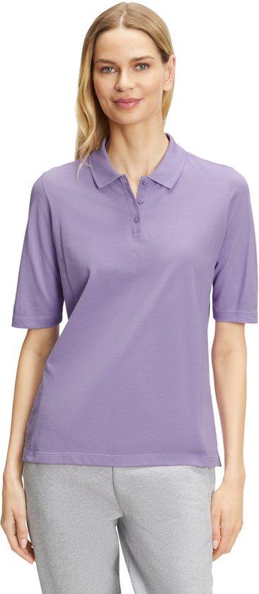 Vrouw met blond haar in een paars poloshirt met korte mouwen en grijze joggingbroek, van voren gezien.