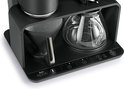 Detail van de bedieningsknoppen 'Melitta Epos', 'Grind' en 'Brew' op een zwart koffiezetapparaat.