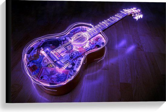Gitaar bedekt met stickers en omlijst met paarse neonverlichting, liggend op een houten vloer.