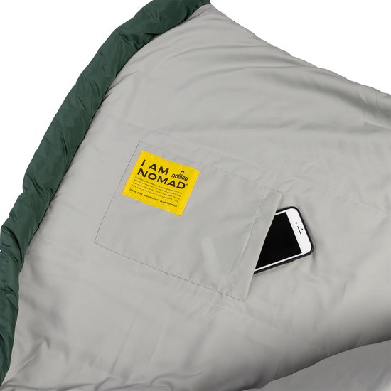 Groene slaapzak met lichtgrijze voering, binnenzak met smartphone en een gele "I AM NOMAD" sticker.